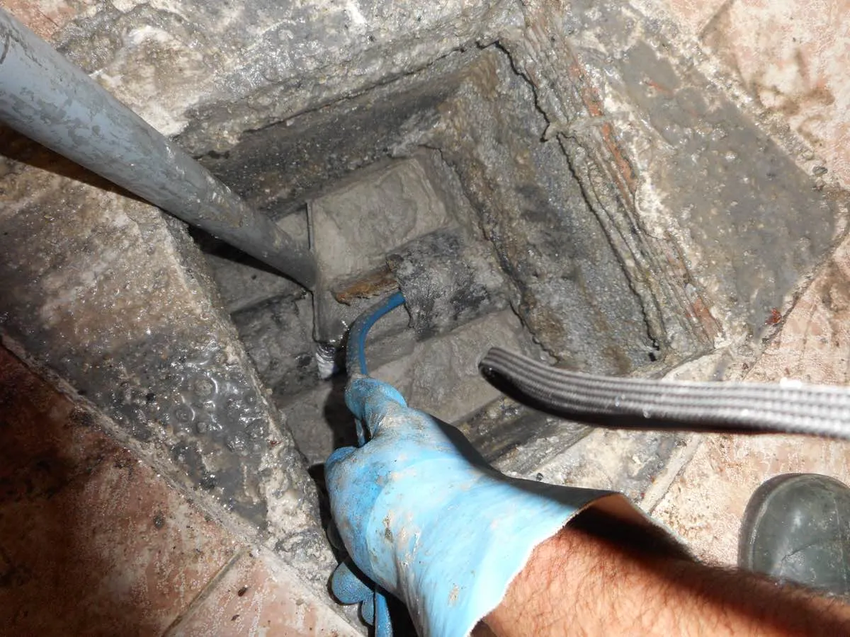 Manguera de desatasco trabajando dentro de una arqueta