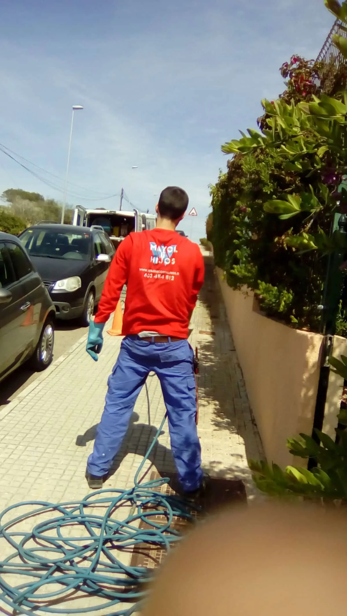 Operario de Mayol e Hijos con la manguera de presión en la calle