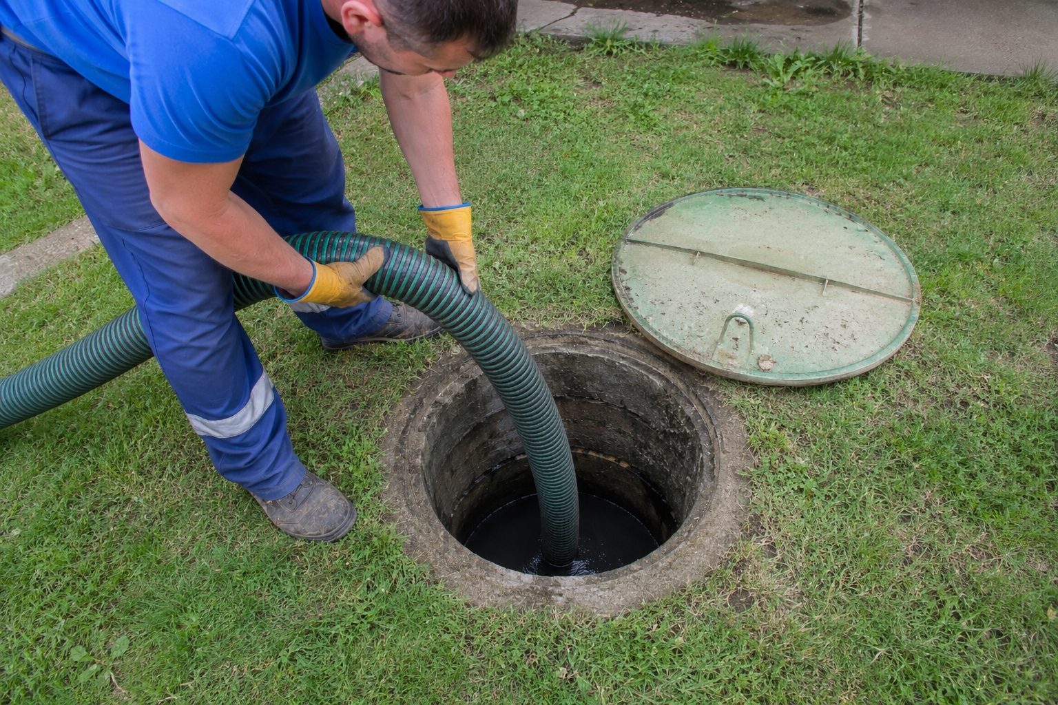 trabajador limpiando pozo séptico